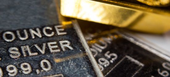 A gold bar resting on stamped one-ounce .999 fine silver bullion bars.